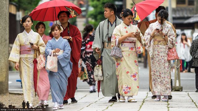familia-con-kimono-en-kioto-usando-tecnologia-moderna-movil